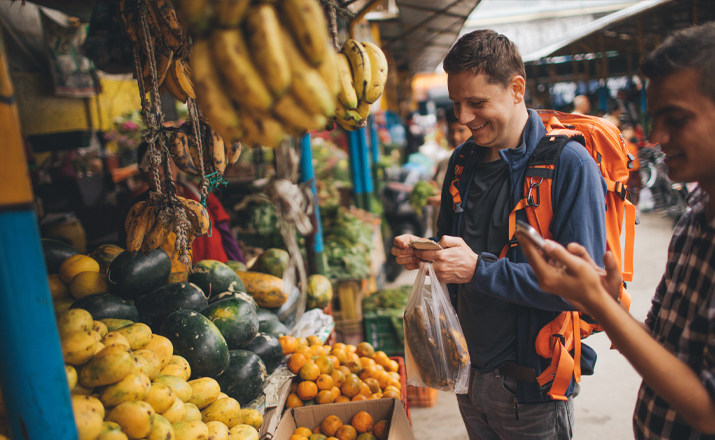 A man buying fruit from a market stall